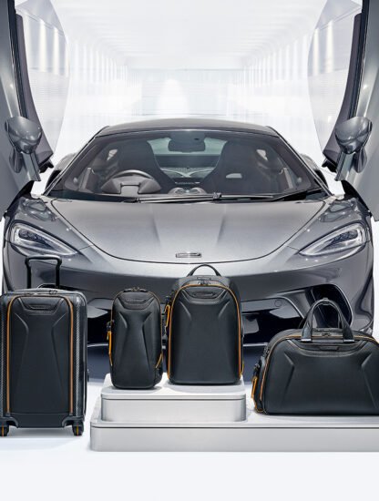 TUMI McLaren_Lifestyle_Aero International Expandable 4 Wheeled Carry-On in Black and Torque Sling in Black and Velocity Backpack in Black and Quantum Duffel in Black