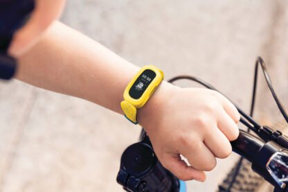 Fitbit_Ace_3_Lifestyle_Minions_Yellow_Sidewalk_Boy_with_Bike_061